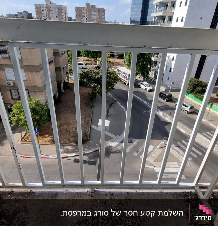 מעקה מתכת לבן עם סורגים אנכיים במרפסת